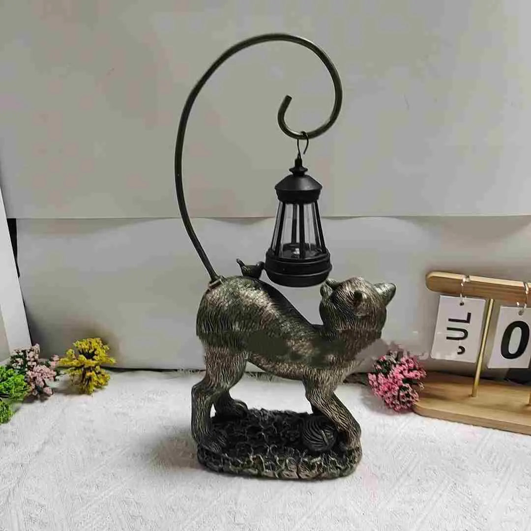 Bronze resin cat solar garden lamp on a garden path, outdoor decoration