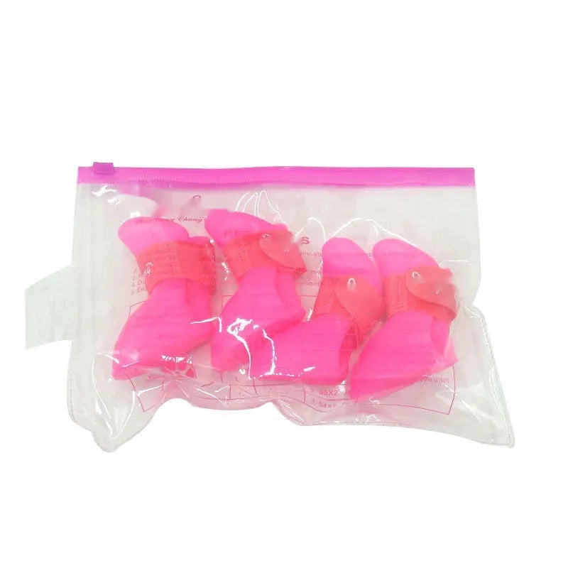 A set of four colourful rubber rain shoes for dogs, showing soft soles and bright pink, blue, orange, and red colours.