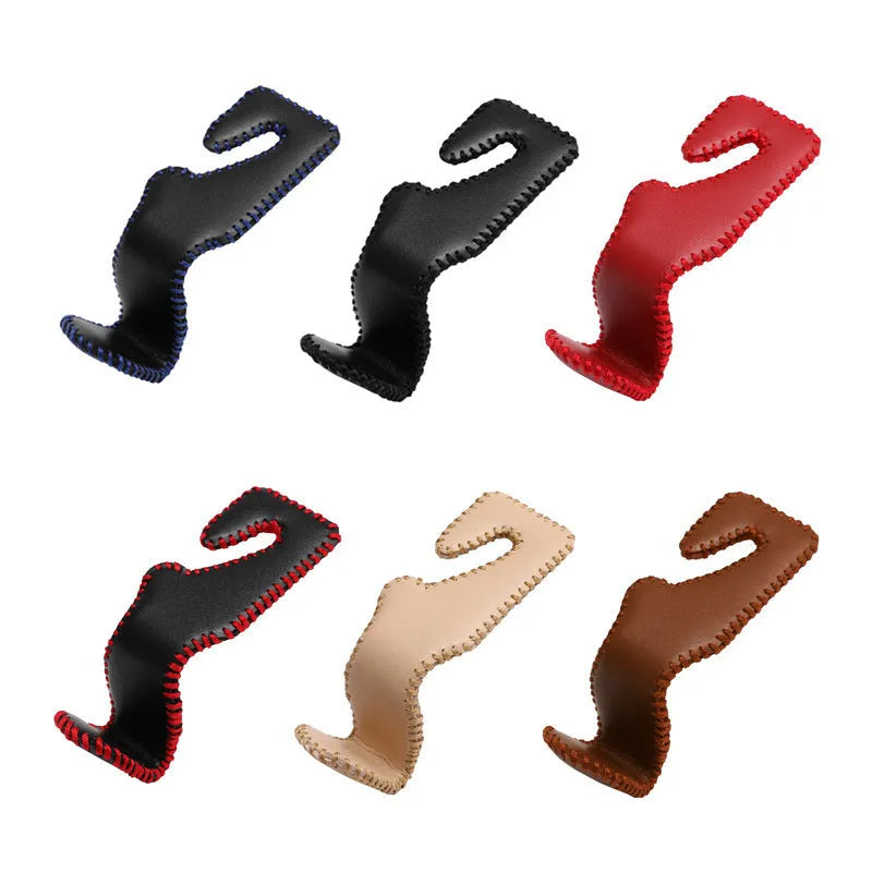 Stainless steel car seat back hook with gold finish clipped onto a car headrest, holding a shopping bag.
