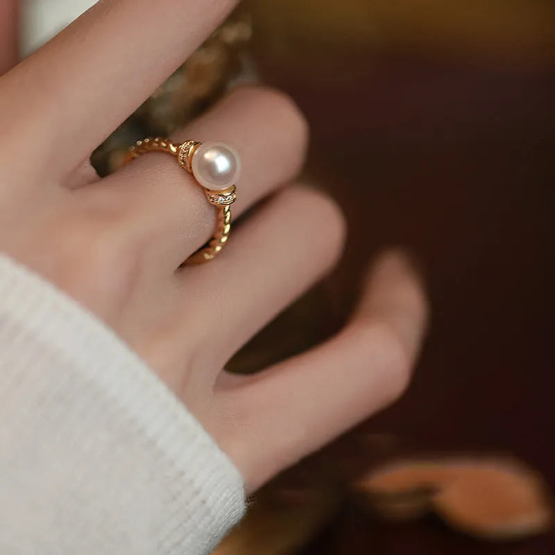 Adjustable antique-finish copper ring with a 6mm pearl set in a geometric twist.