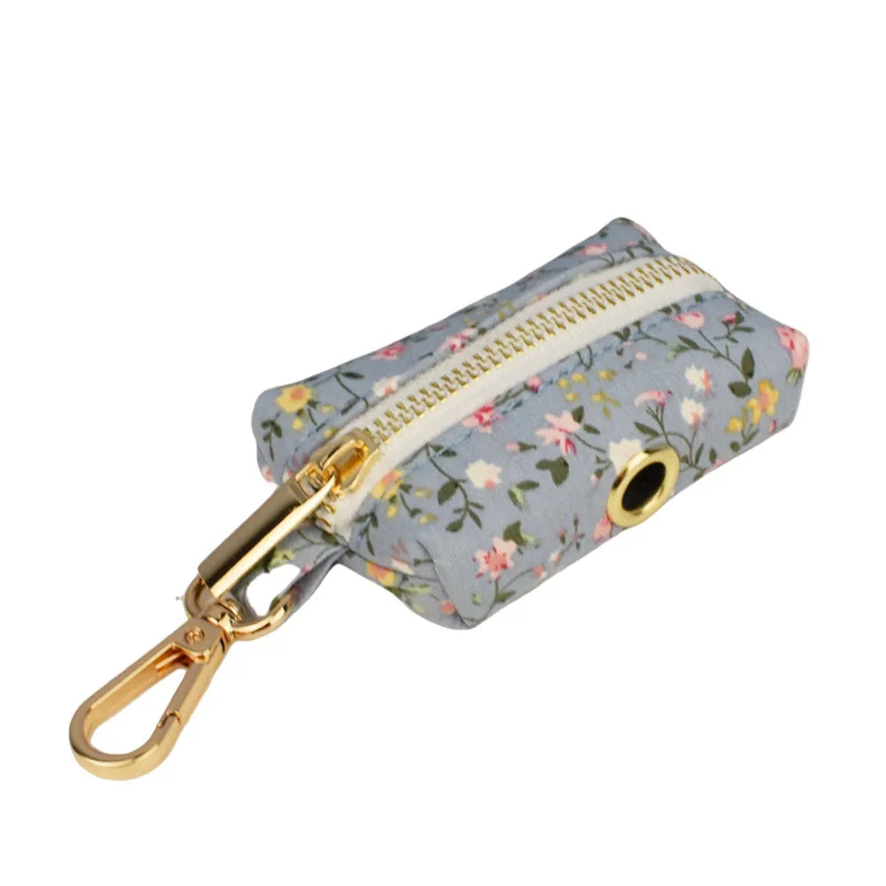 Blue floral dog collar and matching leash, bow, vest, and waste bag holder five-piece pet set.