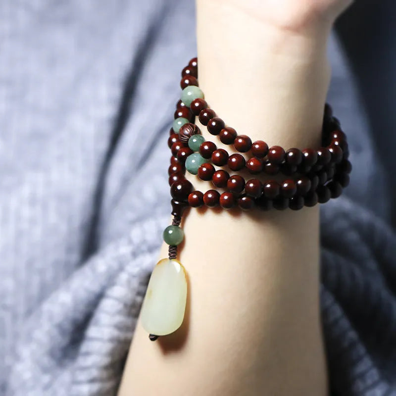 Traditional rosewood prayer bracelet with 108 beads, carved Pterocarpus santalinus decoration, and Hotian jade pendant