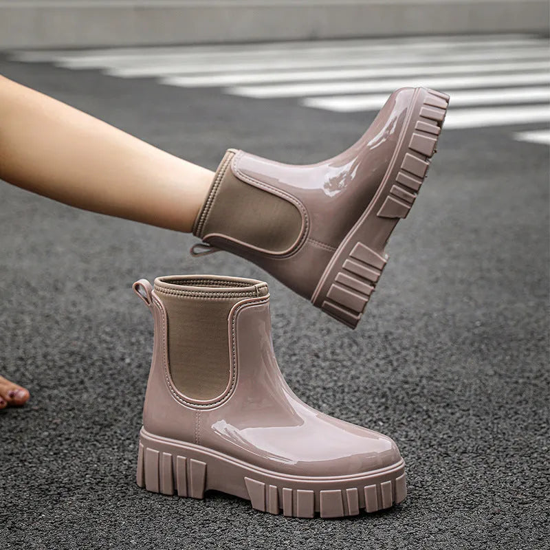 Women's creamy white PVC low tube rain boots with a flat heel on a white background.