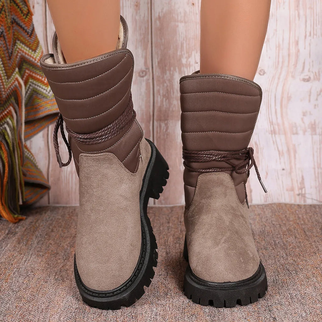 Women's black suede high-top snow boots with chunky rubber sole and lace-up design.