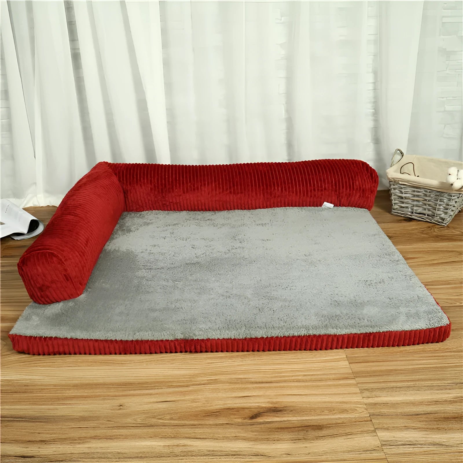 Grey corduroy pet sofa dog bed with bilateral bolsters and a non-slip cloth base on a wooden floor.