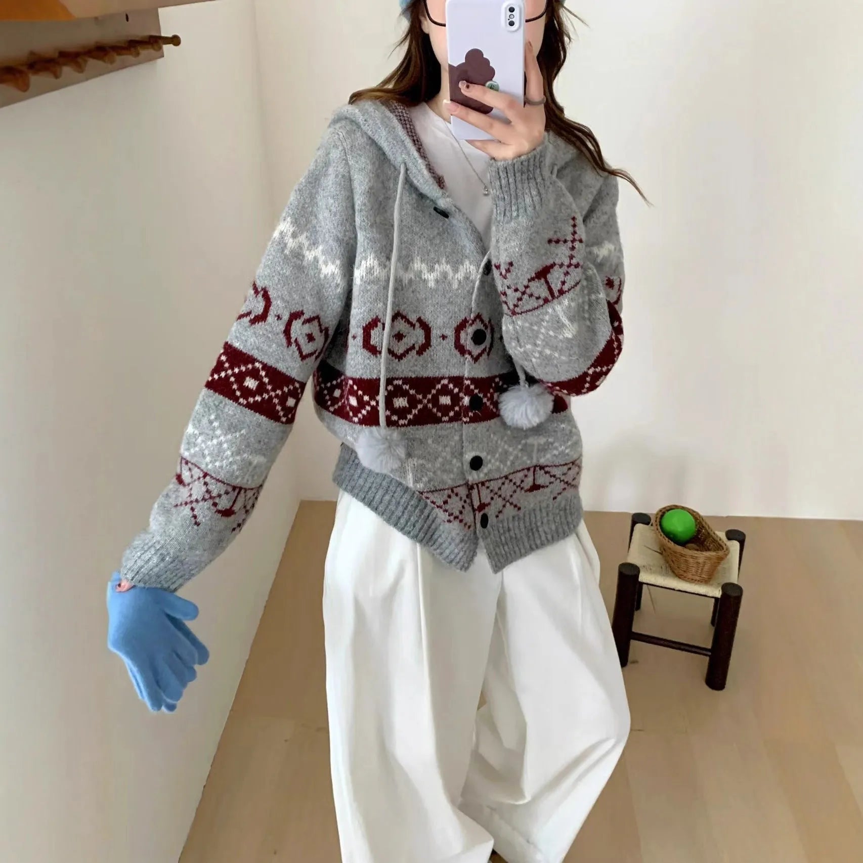 Plus size woman wearing a loose, geometric patterned grey acrylic sweater coat.