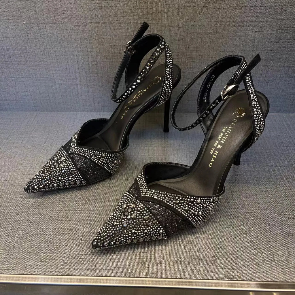 Women's black pointed-toe stiletto heels with a hollow-out design and red sole.