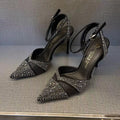 Women's black pointed-toe stiletto heels with a hollow-out design and red sole.