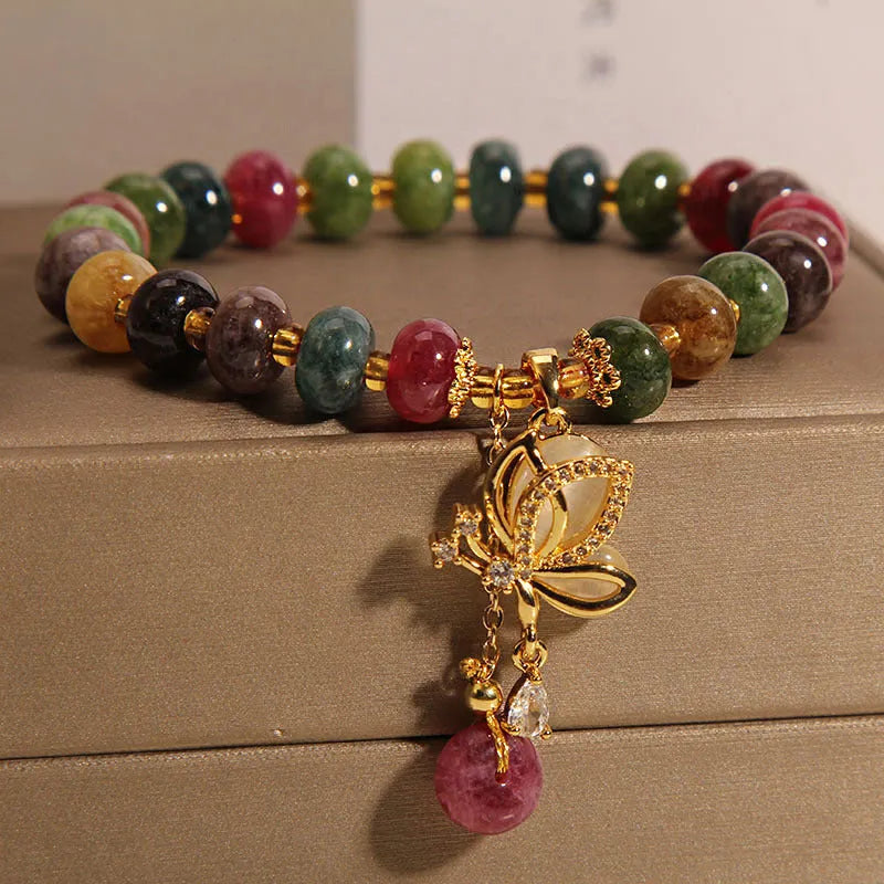 Women's colourful bracelet with alloy butterfly charm and tourmaline beads on wrist.