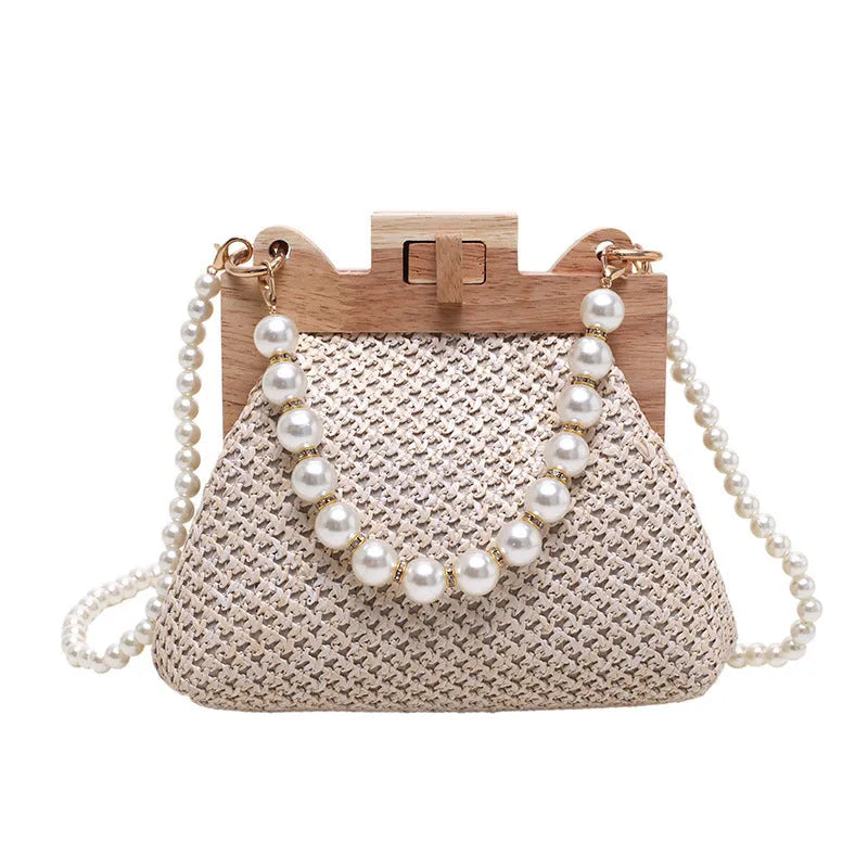 Women's woven straw shoulder bag with pearl chain strap showing internal organisation compartments
