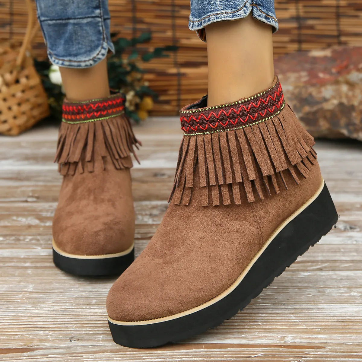 Women's black suede wedge bootie with a thick sole, side zipper, and tassel detail.
