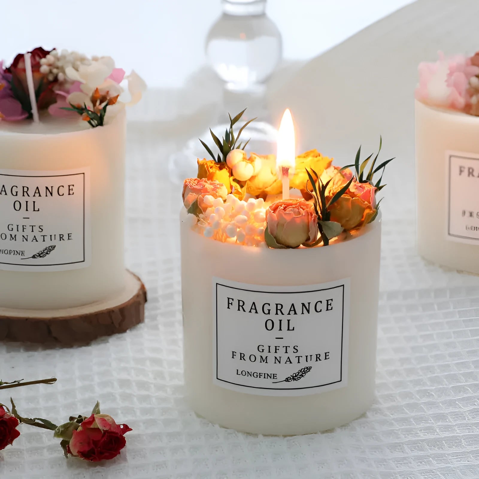 Decorative dried flower candle in jar with wooden chip base, available in nine botanical scents