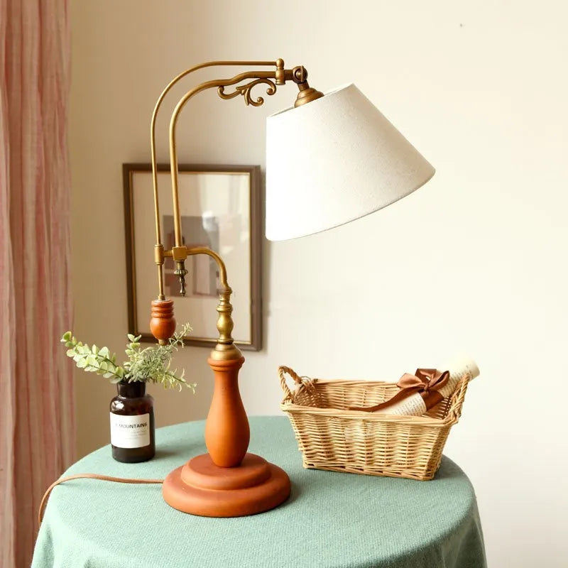 Beige fabric shade wooden bedside table lamp on a wooden surface