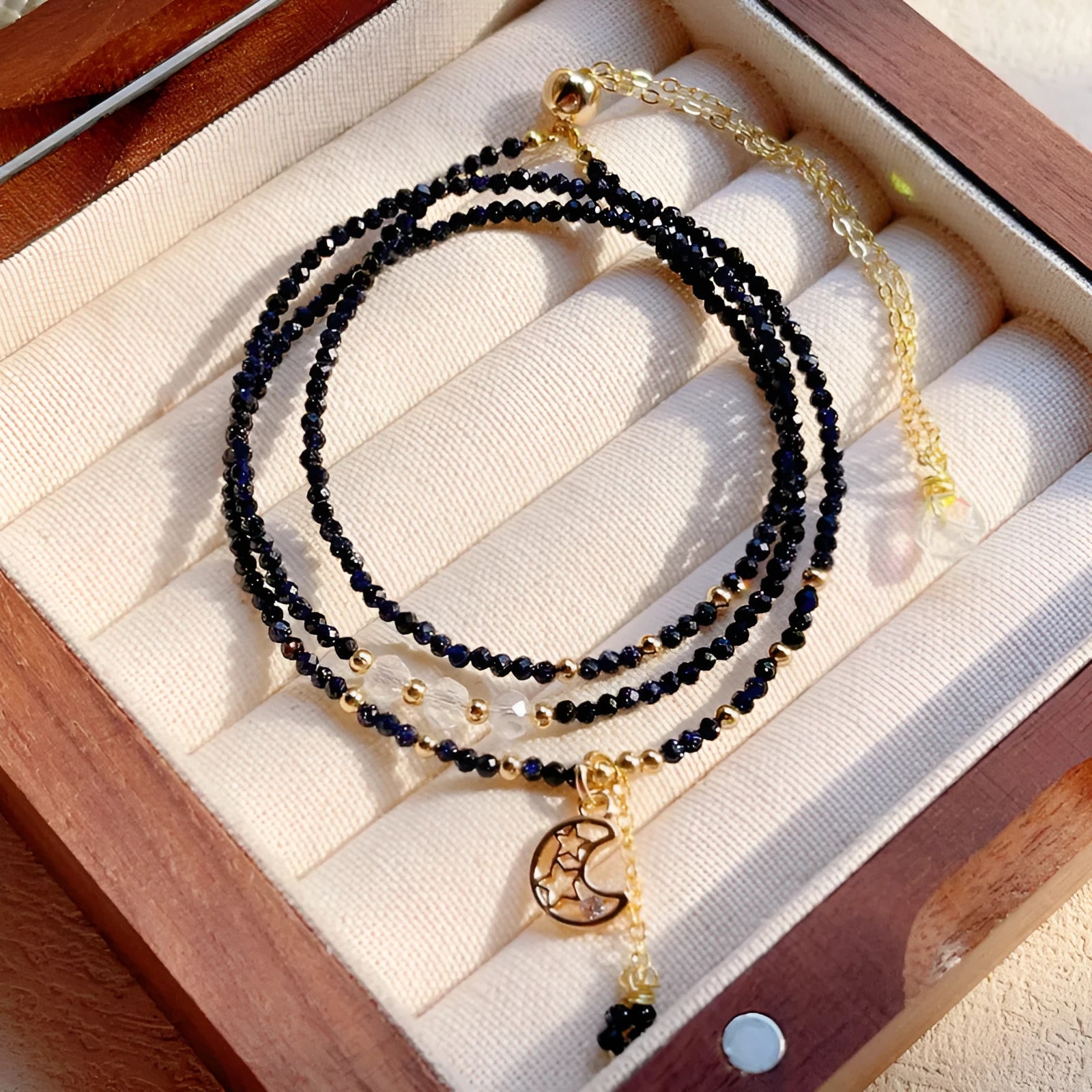 Women's three-ring layered bracelet with blue san stones in gold-toned settings, showing adjustable clasp