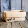 Cement brown paper box design flower pot with bottom drainage holes on a table.