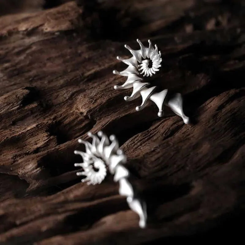 Exaggerated three-dimensional matte conch ear studs in alloy with an irregular simple style.