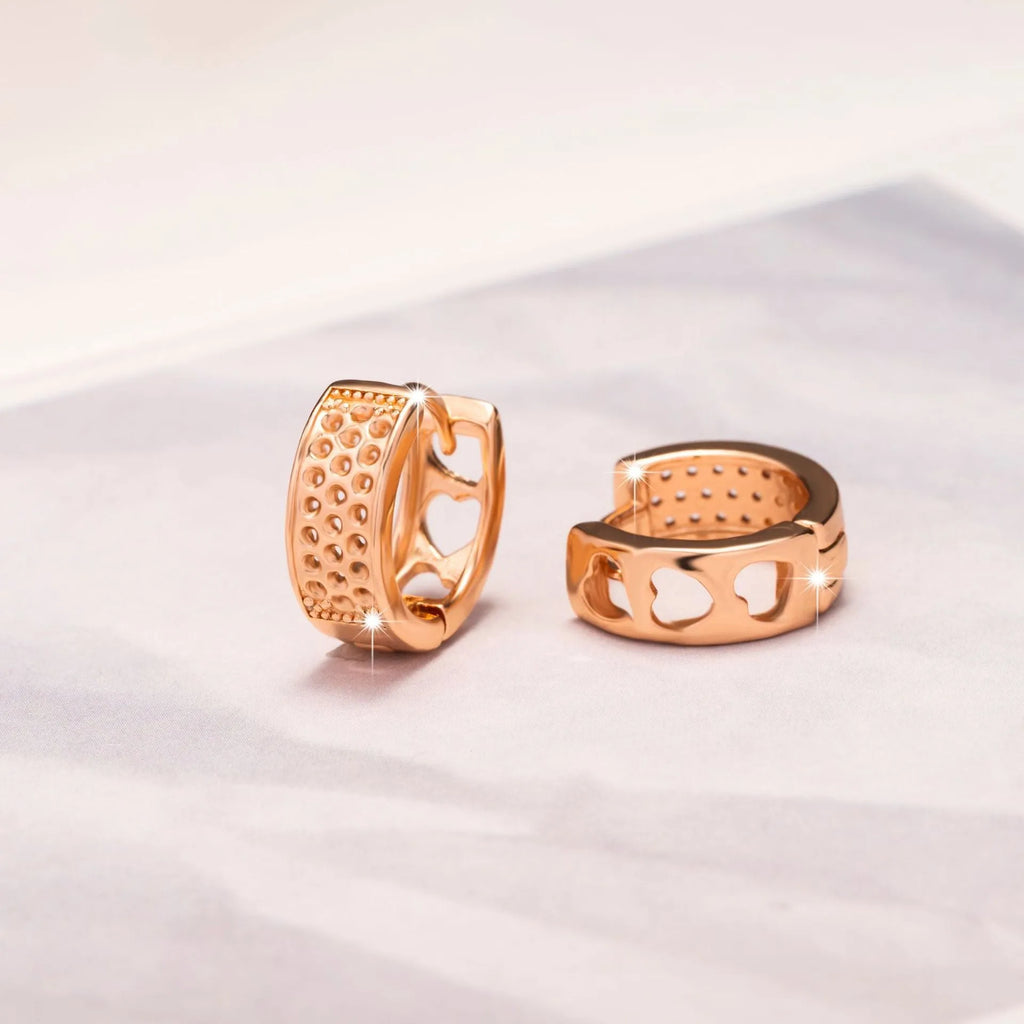 Pair of rose gold women's earrings with a 1.5cm hollow heart shape and three smaller heart cut-outs.