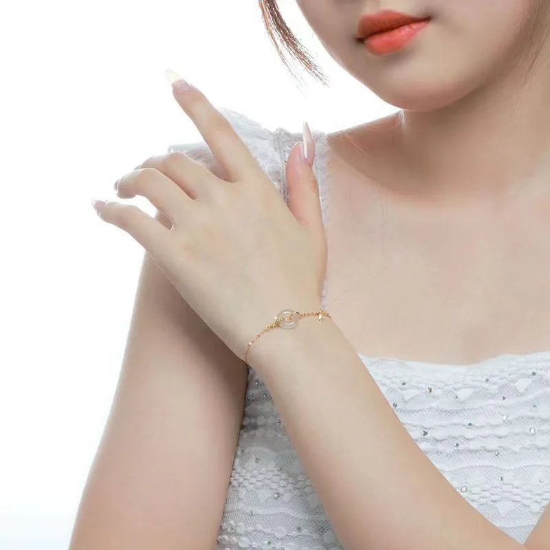 Silver gold electroplated women's bracelet with a white chalcedony stone and prominent peace buckle clasp on a 22 cm band.