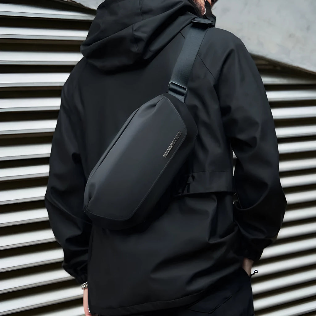 Black men's messenger bag in Oxford cloth with crossbody strap and street style details.