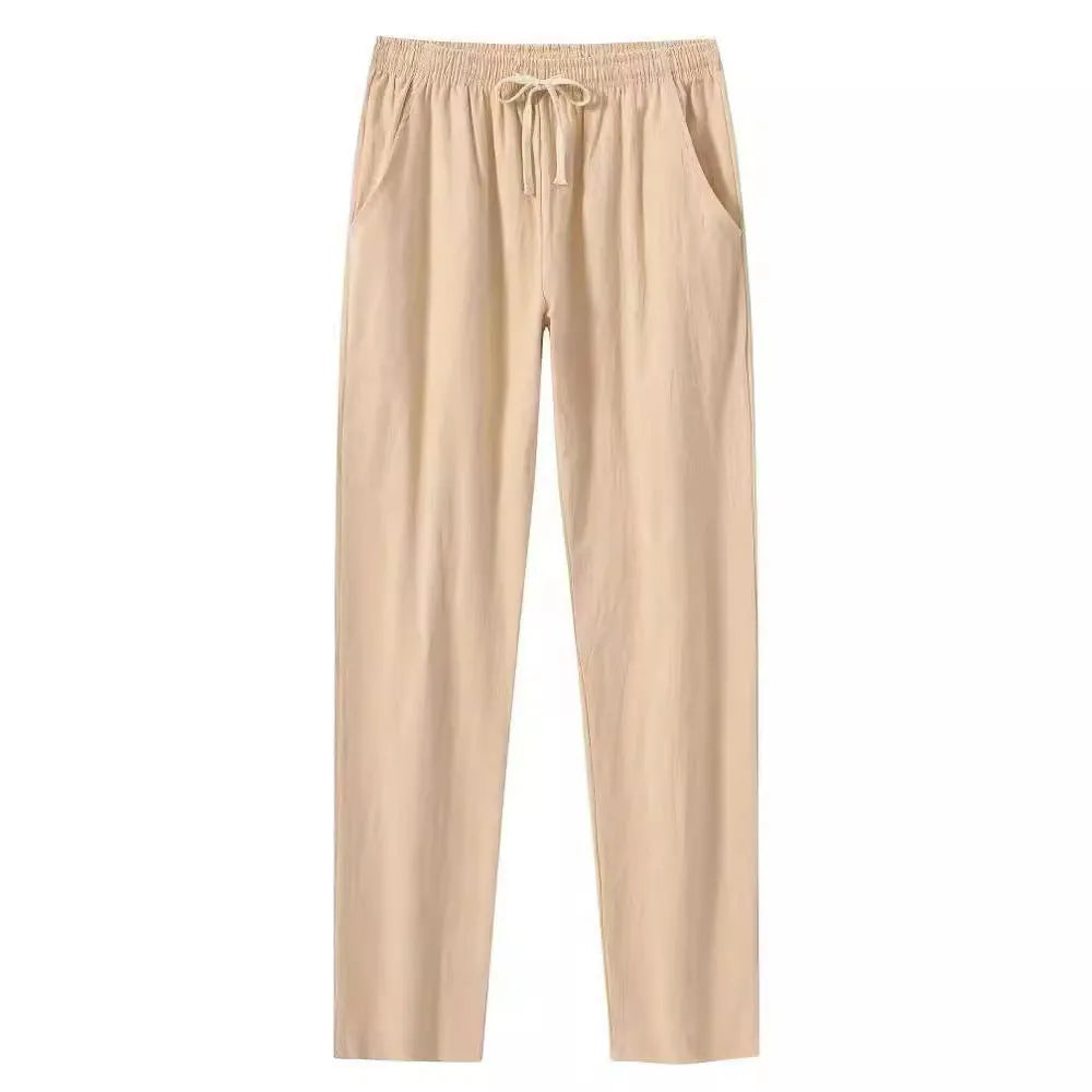 Men's loose-fitting cotton beach trousers in a solid colour, shown in a casual setting.