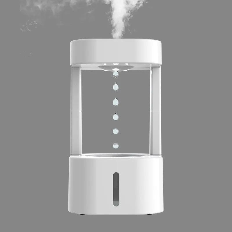 White anti-gravity water drop humidifier with coloured light on a desk next to USB cable