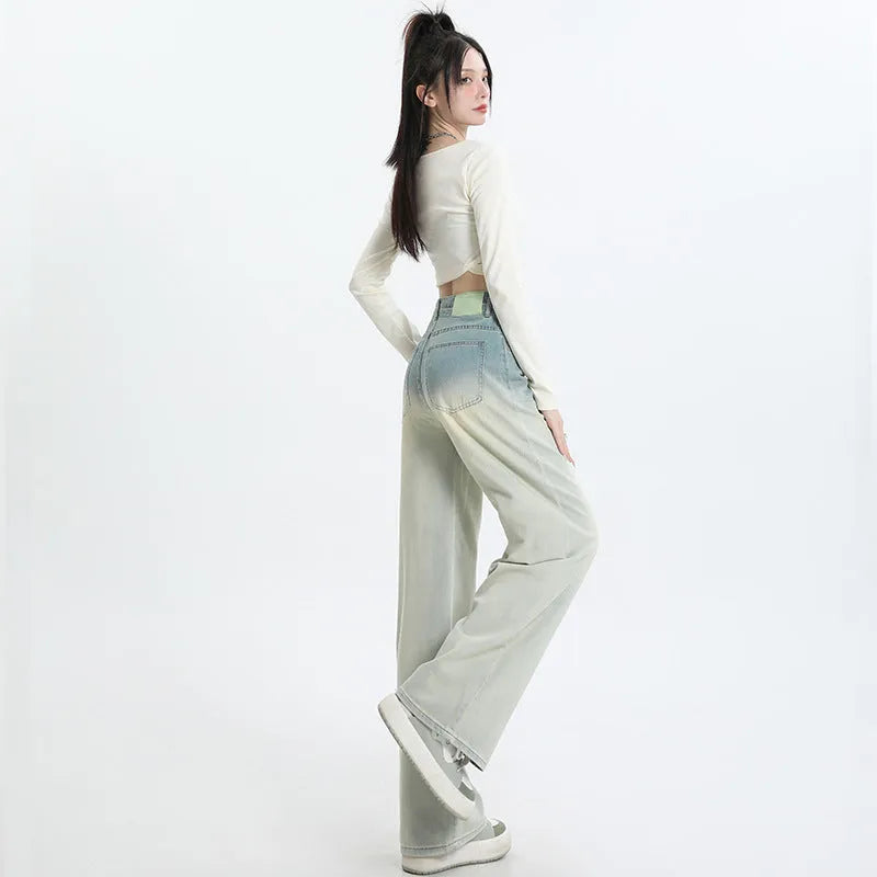Women's gradient blue wide-leg denim trousers on a neutral background.