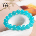 Loose natural green Amazonite beads in various sizes for jewellery making on a white surface.