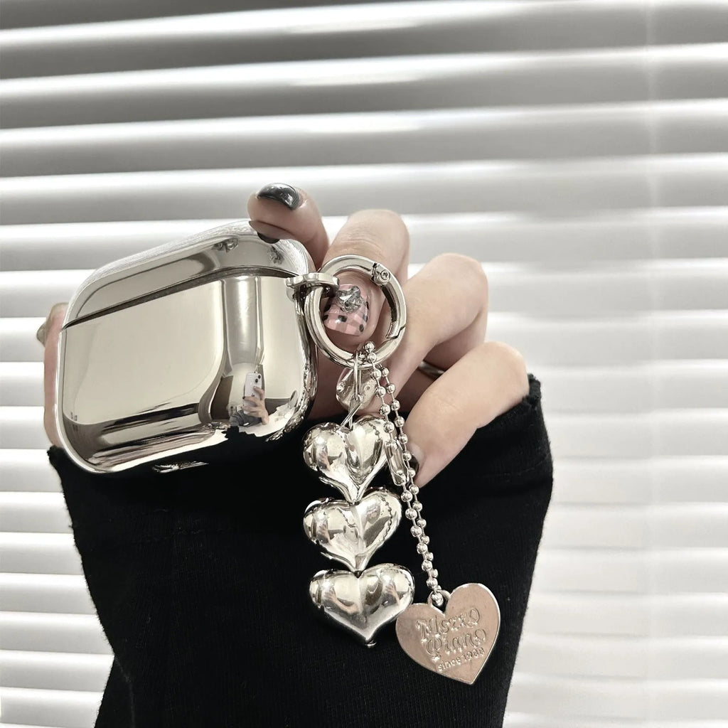 Electroplated solid colour iPhone headphone case with heart pendant attachment on a soft TPU shell.