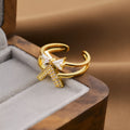Gold geometric open ring for women on a neutral background, showing its adjustable shape and metallic finish.