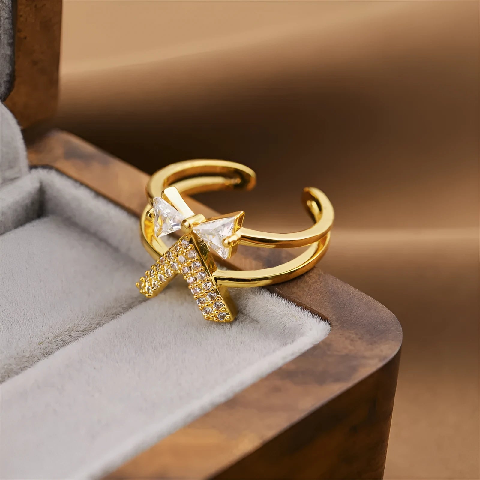 Gold geometric open ring for women on a neutral background, showing its adjustable shape and metallic finish.
