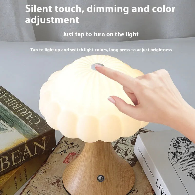 Wood grain coloured mushroom-shaped touch lamp with USB charging port on a bedside table.