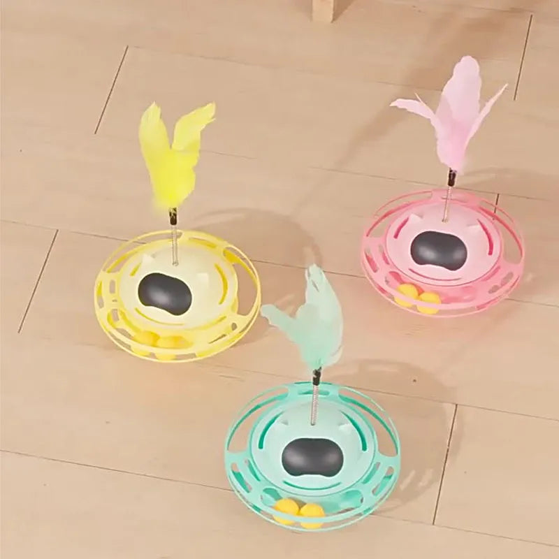 Pink cat tumbler turntable toy with feather attachments on rotation platform
