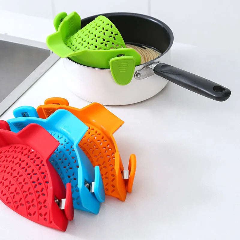 Green silicone pot drain stopper with stainless steel insert on a kitchen countertop.