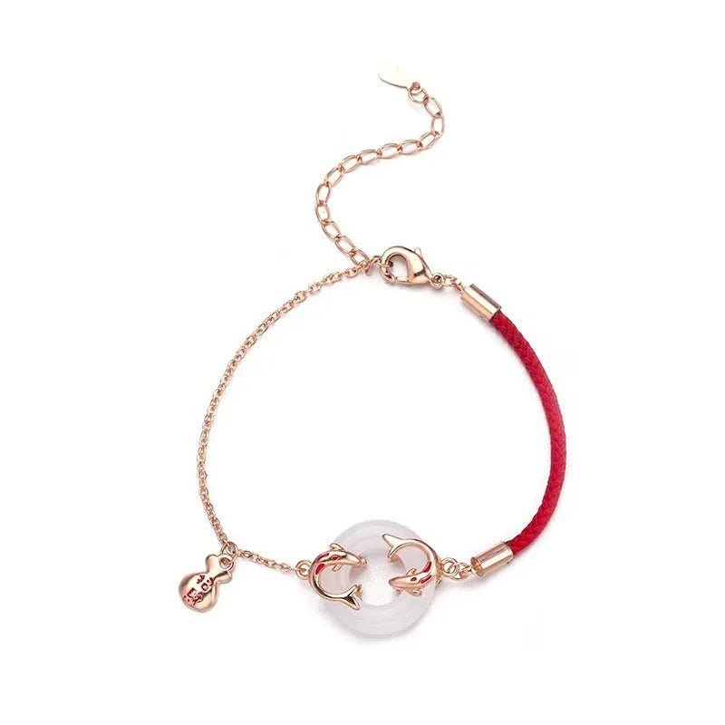 Close-up of a red rope festive koi bracelet for women with a peace buckle and fish tail details.