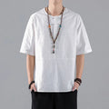 Man wearing a black loose-fit linen t-shirt with a retro jacquard pattern and fastener decoration.