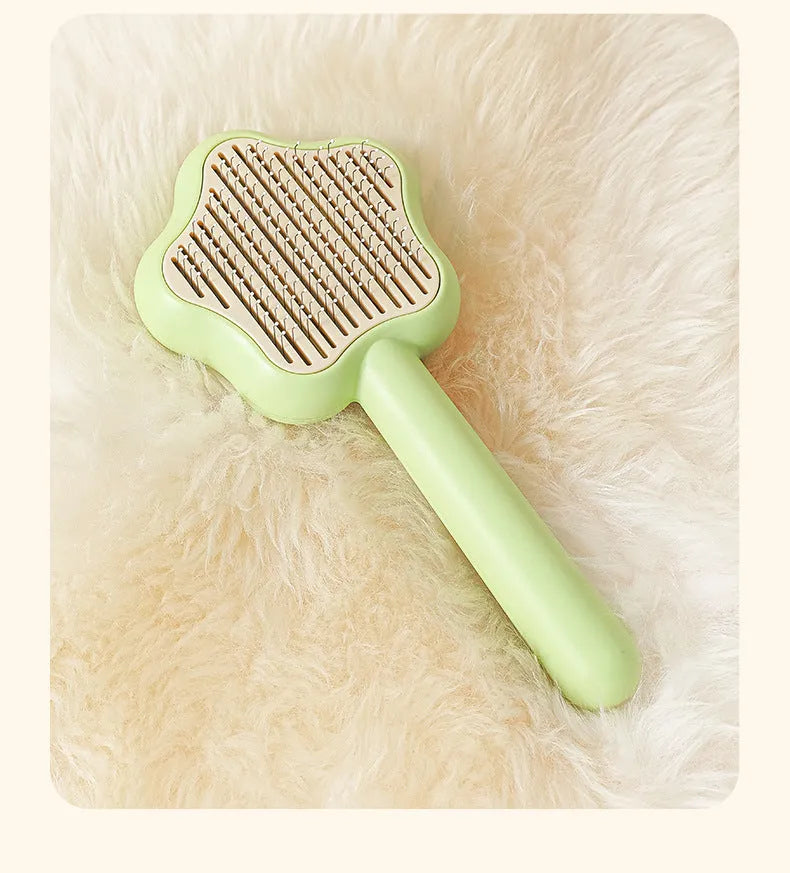 Green self-cleaning stainless steel magic wand cat comb on a white background.