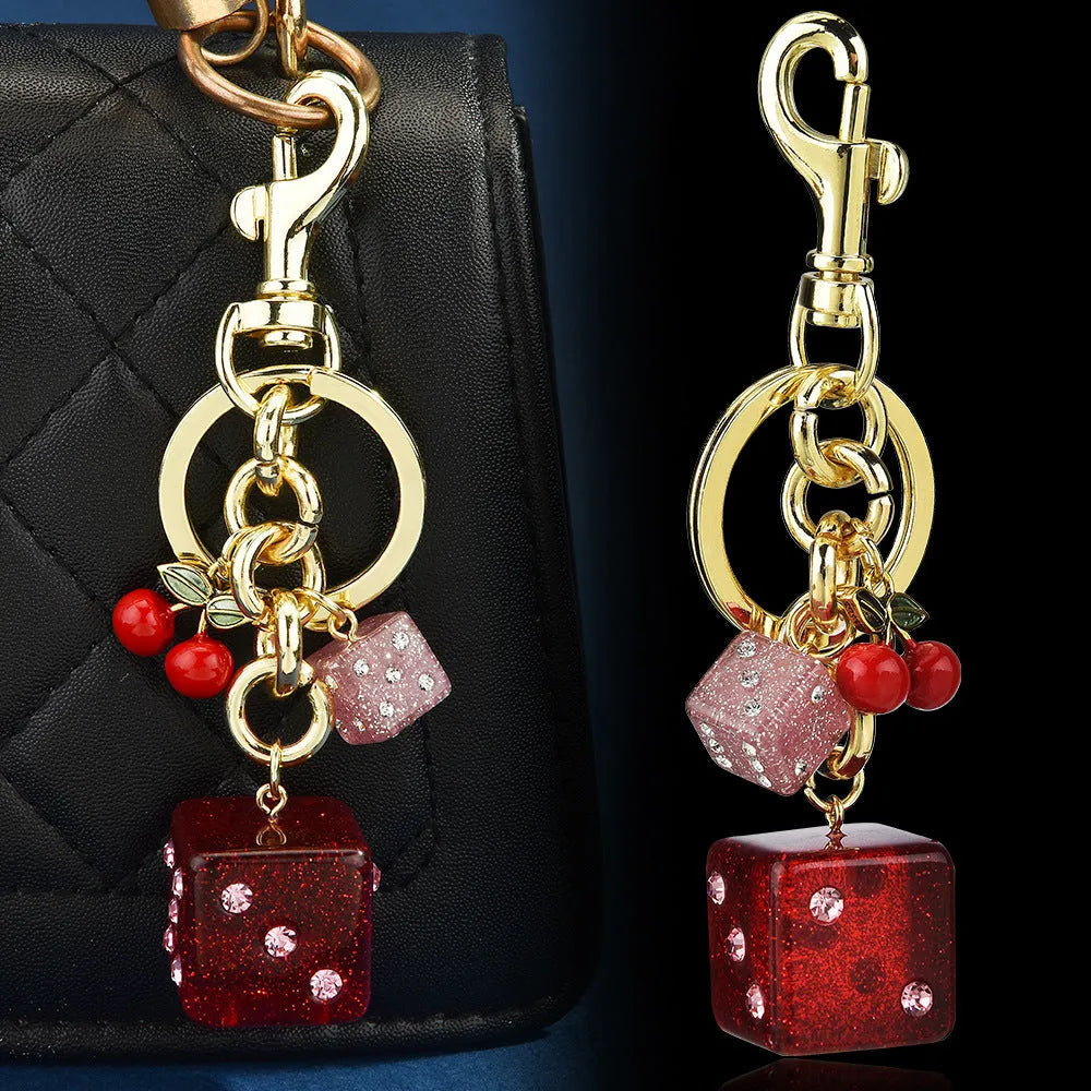 Vintage-style metal keychain with a square cherry red and white two-tone dice pendant on a metal ring.