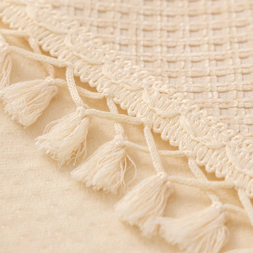 Ivory white non-slip short plush polyester sofa cover with tassle fringe on a sofa seat