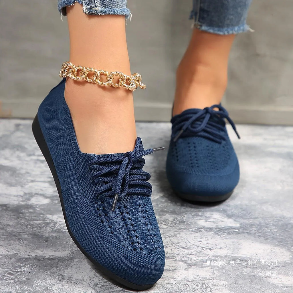 Women's breathable mesh lace-up flats with cross strap, round toe, and flat rubber sole in black, blue, brown, or light grey.