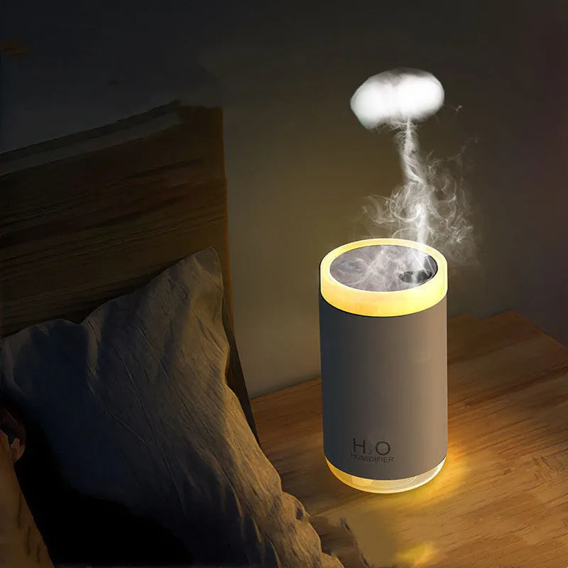 Blue jellyfish USB humidifier with night light on wooden table, showing mist output