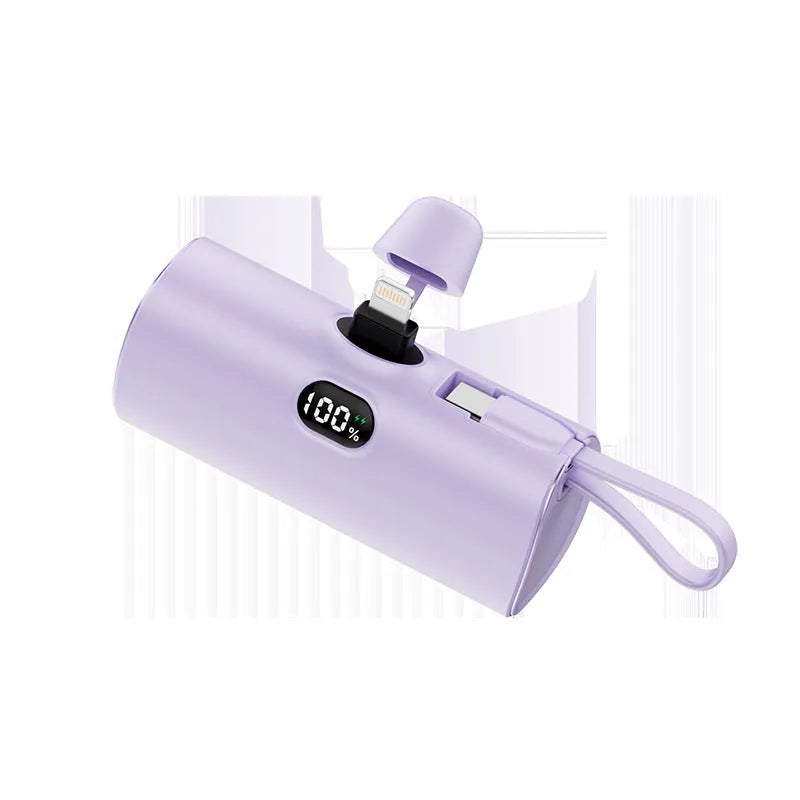Compact capsule-shaped wireless power bank with digital display and folding plug.