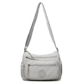 Soft water-repellent nylon crossbody bag with a three-dimensional front pocket and adjustable strap.
