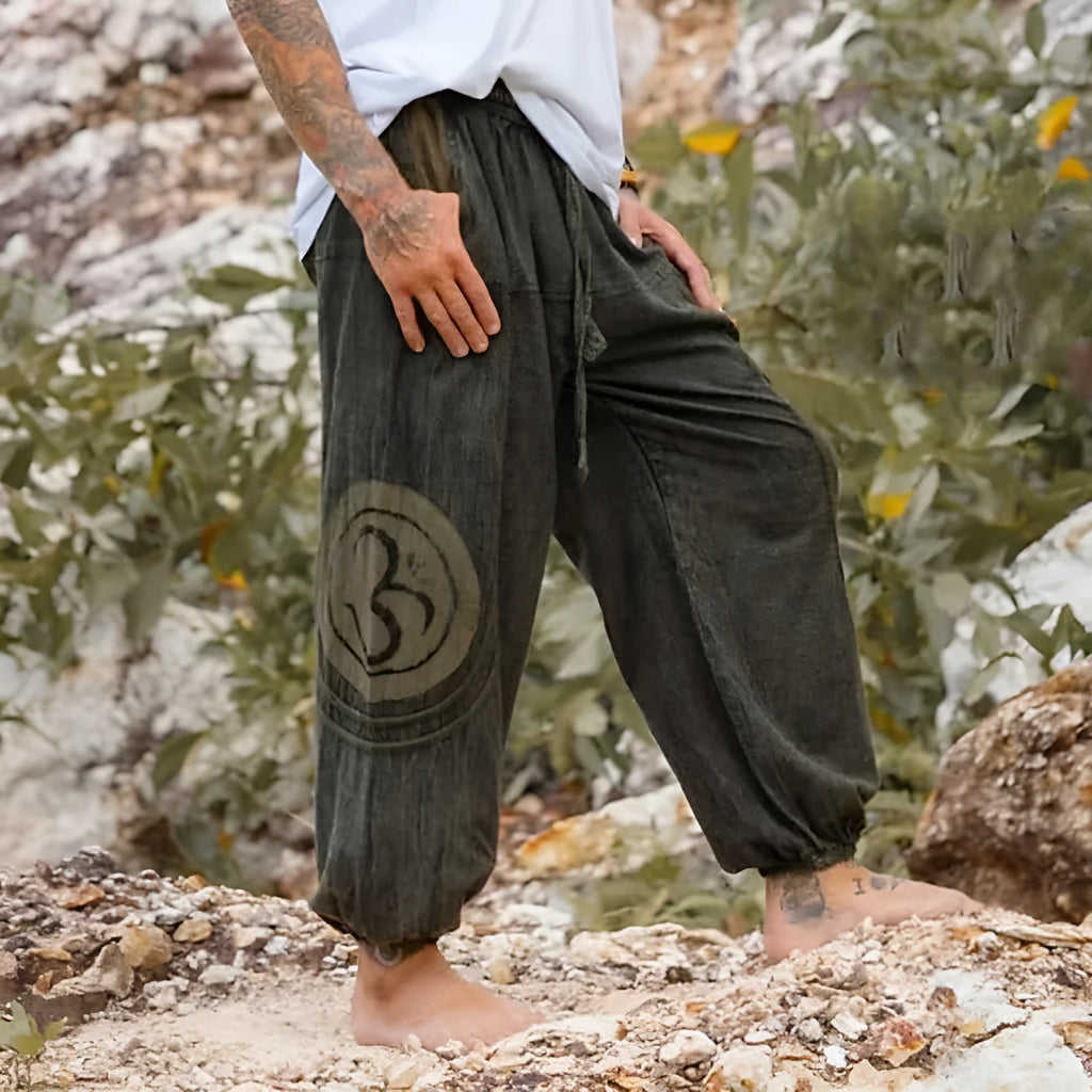 Dark green men's trousers with ethnic pattern design showing ankle-tied detail and mid-waist fit