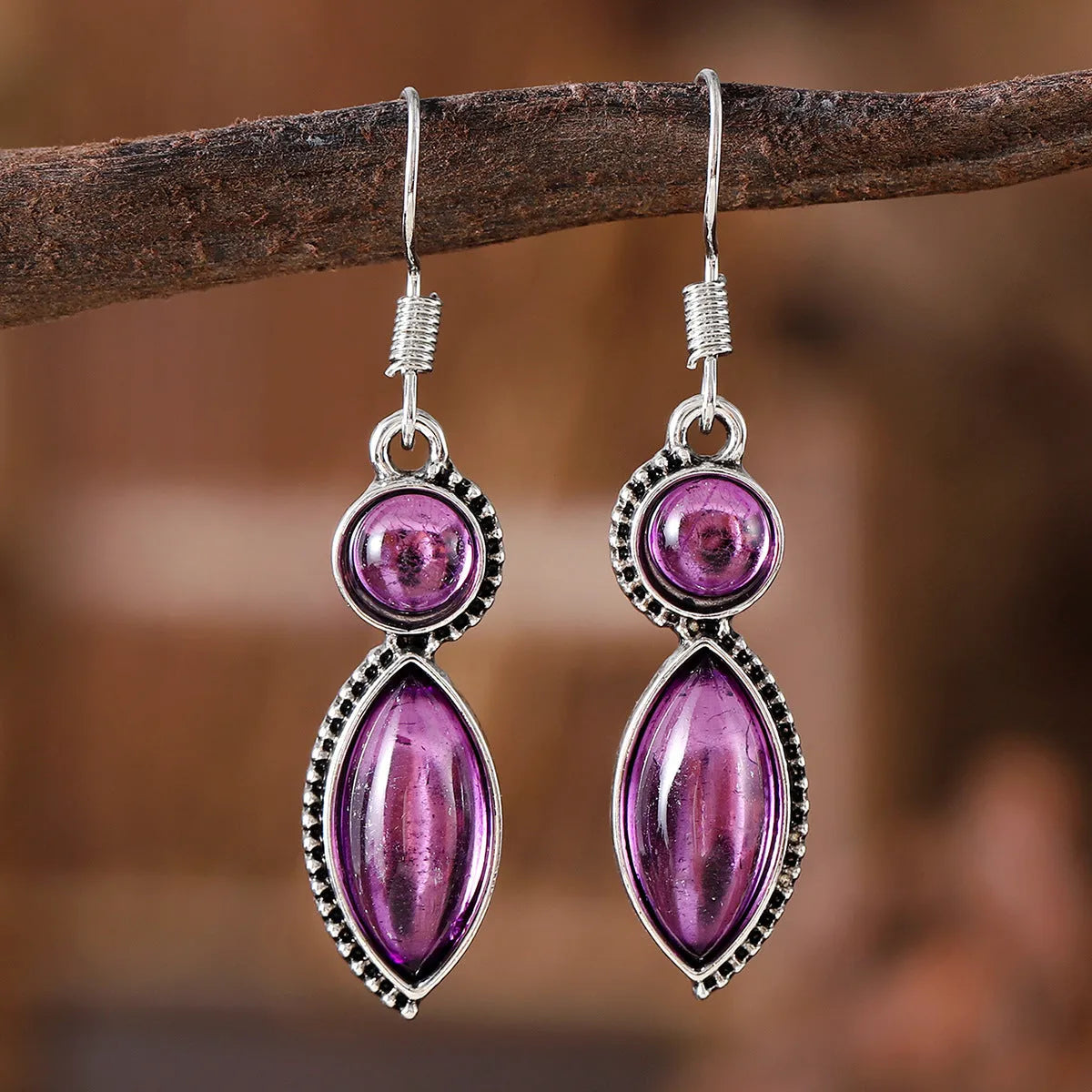 A pair of black and purple vintage geometric drop earrings with a round detail, shown against a plain background.