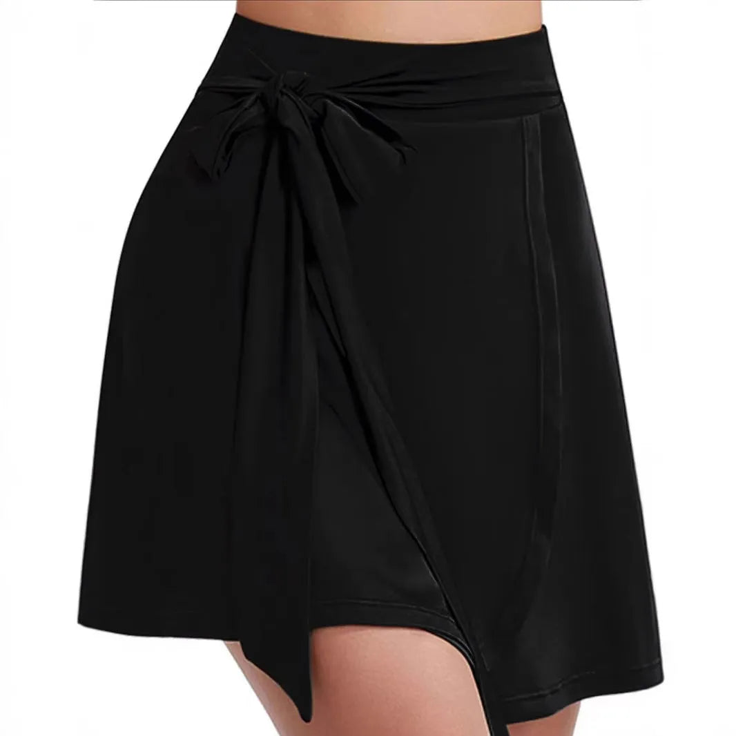 Black thigh-length sports skirt with built-in shorts, high waist, and shoulder strap details.