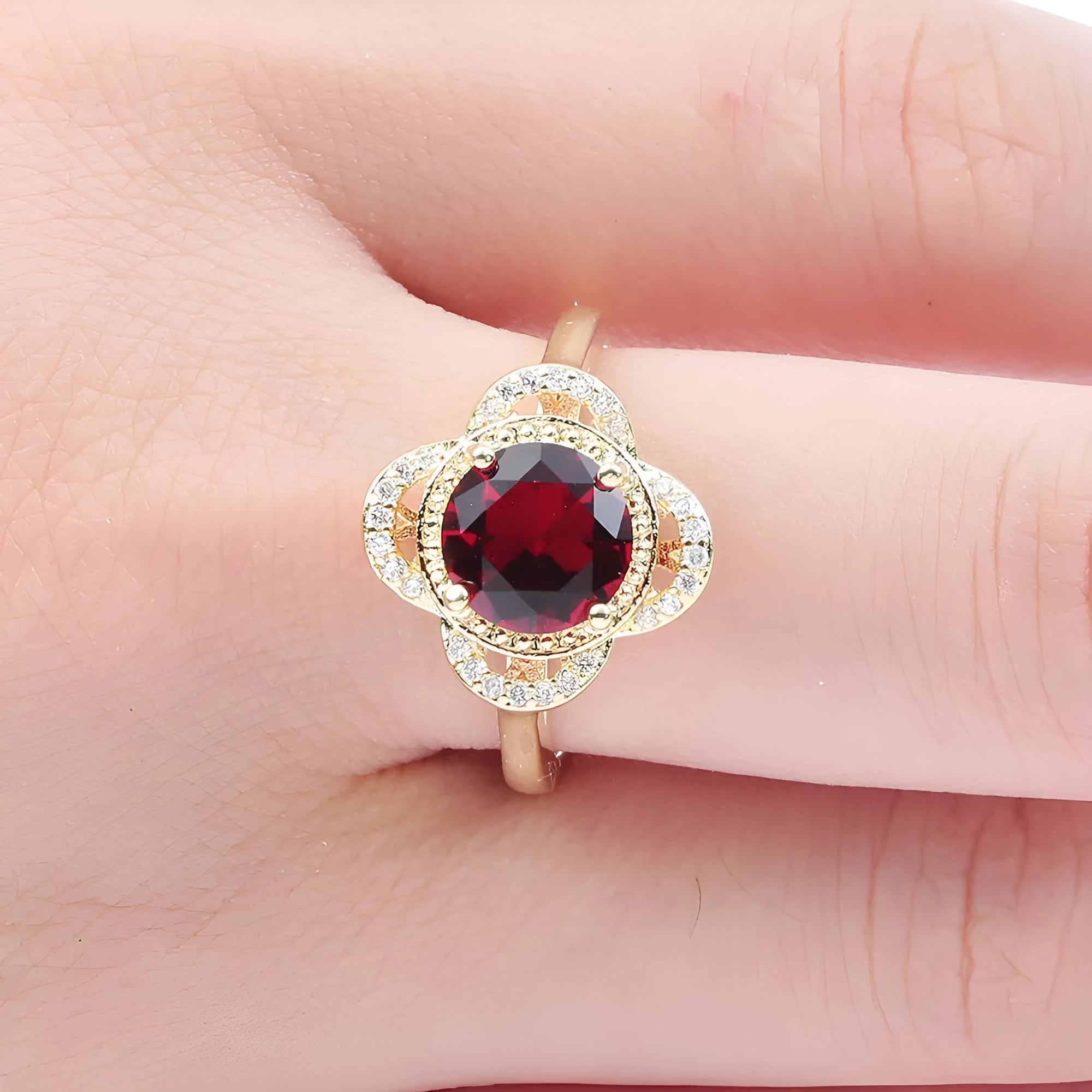 Copper fruit-shaped ring with inlaid zircon stones on a finger.