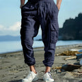 Men's loose-fit linen trousers with ankle ties and a drawstring waist in a solid colour.