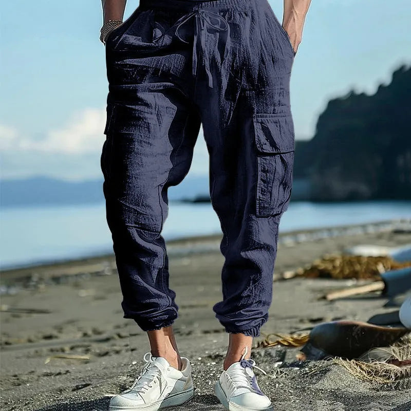 Men's loose-fit linen trousers with ankle ties and a drawstring waist in a solid colour.