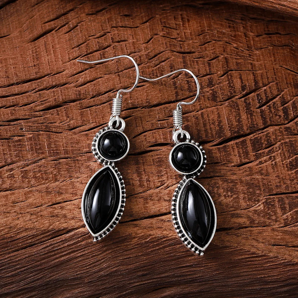 A pair of black and purple vintage geometric drop earrings with a round detail, shown against a plain background.
