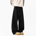 Men's relaxed dark grey or black trousers with drawstring waist, slight stretch, and included belt